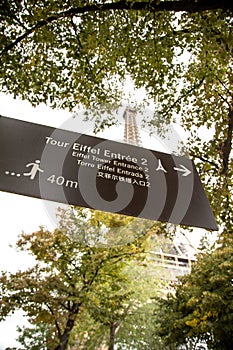 Sign post indicating the entrance to the Eiffel tower