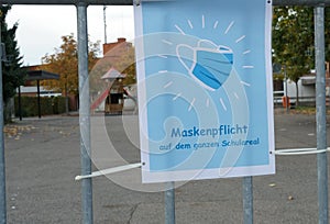 A sign poster in German language saying a face mask is obligatory on school ground. photo