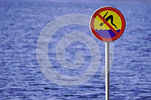 Sign prohibiting diving on the background of water, river or lake. the safety of people, shallow body of water.