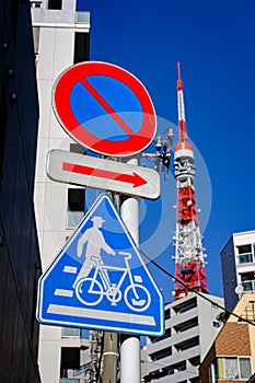 The sign prohibits the car to drive into, Direction sign and Bicycle Leash Sign with Tokyo Tower and buildings backgrounds