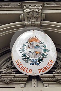 A sign on a public school with Uruguayan coat of arms