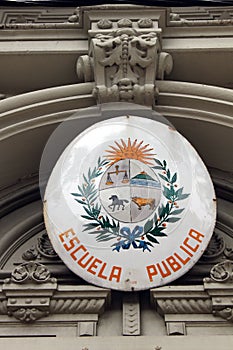 A sign on a public school with Uruguayan coat of arms photo