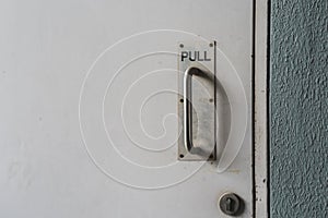 sign `Pull` at a door with handle