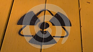 Sign of radiation on a yellow wooden board.