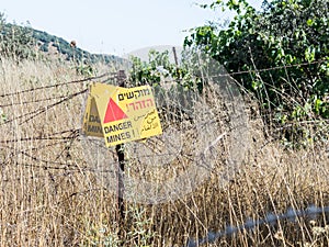 A sign reading `Danger Mines!` hangs from a barbed wire fence in the Golan Heights, near the border with Syria, Israel