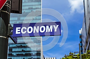 A sign that reads economy on a post. City background, clear sky and sunny day