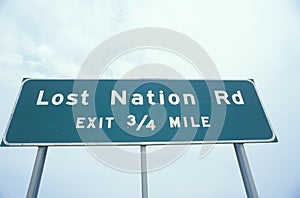 A sign that reads ï¿½Lost Nation Rd - Exit 3/4 mileï¿½