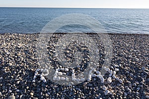 The sign Relax made from white pebbles on pebble beach on the se