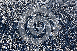 The sign Relax made from white pebbles on pebble beach on the se