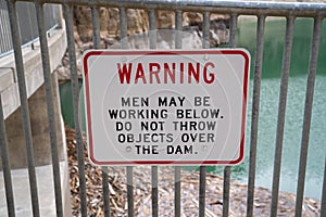 Sign reminding tourists for the Buffalo Bill Dam in Cody Wyoming not to throw items, as men are working photo