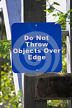 A sign requesting objects not be thrown over a platform edge