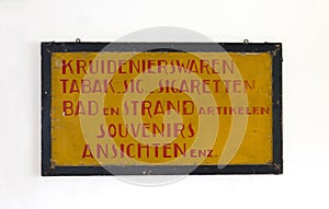 Sign saying `groceries, tabaco, cigarettes, bath, beach, souvenirs and postcards` in dutch photo