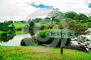 Sign says Careful with Cultural remainings at the Japanese Garden with Full of Green. The good season for nature to visit Japan is