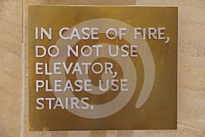 A sign that says, In Case Of Fire, Do Not Use Elevator, Please Use Stairs, which direct people of what to do in case of an fire