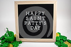 A Sign That Says Happy Saint Patty`s Day With Glitter Clovers and Gold Coins Around