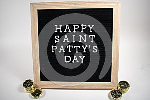 A Sign That Says Happy Saint Patty`s Day With Gold Coins on Each Side