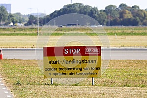 Sign at Schiphol Amsterdam Airport with Stop - Start and landin strip in dutch language