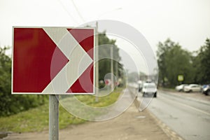 Sign sharp turn. Red road sign. Arrow pointer on road