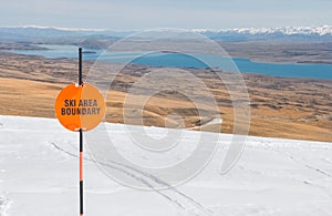 Sign Ski area boundary and view to a lake