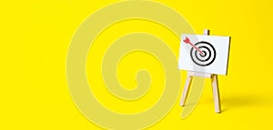 Sign stand with an arrow in the target on a yellow background. Hit exactly on center. Tactics of advertising targeting. advertise photo