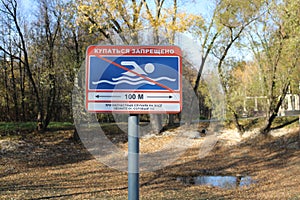 Forbidding sign Swimming is forbidden near a puddle in the autumn Park
