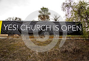 Sign Stating Church Is Now Open in black and white letters