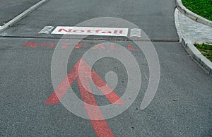 Sign on the street or asphalt road showing a emergency room, ER, in German language