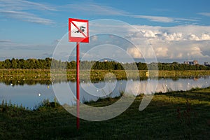 Sign `swimming is forbidden` on the bank of the academic rowing channel