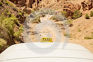 Sign of a taxi on an off-road jeep bringing people up in a mountainous area