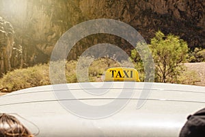 Sign of a taxi on an off-road jeep bringing people up in a mountainous area