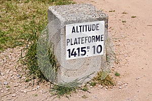 Sign text on concrete bollard top of Puy de dome volcano mountain indicating the altitude 1415 meters in Auvergne France