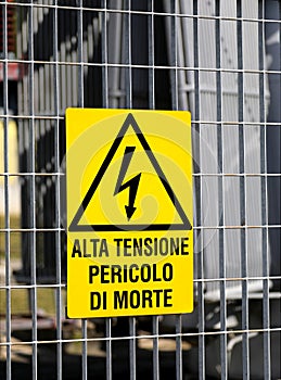 sign with the text high voltage danger of death in italy with the triangle and the lightning outside the electrical substation photo