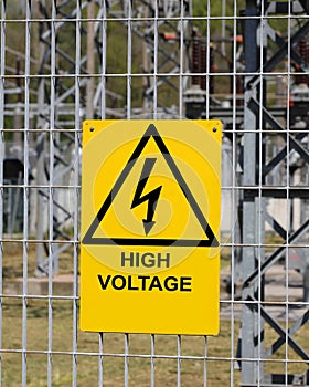 sign with the text high voltage with the triangle and the lightning outside the electrical substation photo