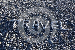 The sign Travel made from white pebbles on pebble beach on the s