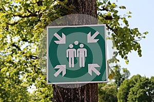 A sign on the tree indicates the gathering place