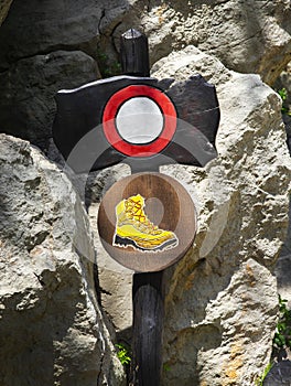 Sign under rocks for using hiking boots