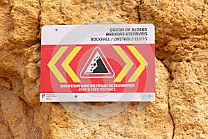 sign with warning of danger of collapsing cliffs on the beach