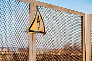 The sign warning about danger of electricity on a metal fence