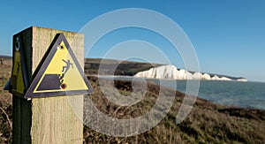 Sign warning of the danger of erosion at the cliff edge overlooking Seven Sisters at Seaford in East Sussex, south coast of UK