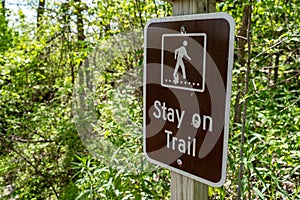 Sign warning and reminding hikers to stay on the trail