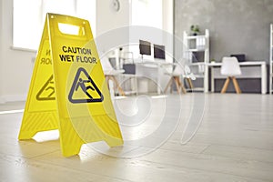 Sign warning about wet floor placed in the office by a commercial cleaning service