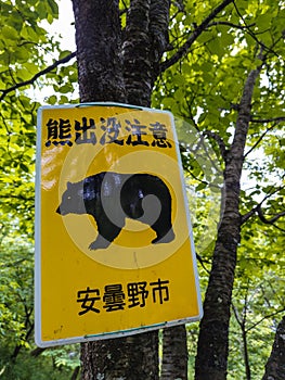 A sign warning of wild bears in Nagano, Japan. Text reads \