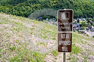 Sign warns hikers of a danger of falling, not an approved trail, to stay out of area. Concept for selfie deaths