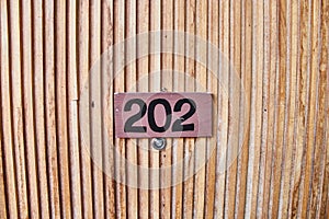 Sign on the wooden door. Room number in the hotel.