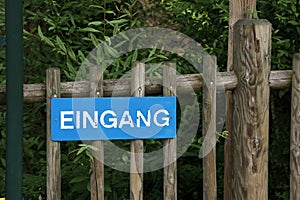 Sign on a wooden fence in German - Entrance