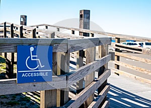 Sign on a wooden handicapped accessible ramp for use by the disabled