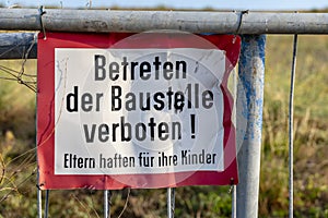 Signage of a construction site at a fence: Enter the construction site prohibited! Parents are responsible for their children