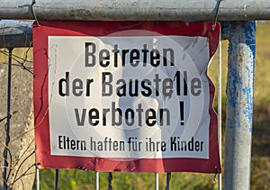 Signage of a construction site at a fence: Enter the construction site prohibited! Parents are responsible for their children