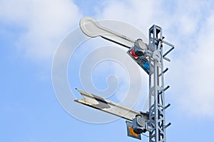 Signal caution pole of train with cloud and blue sky