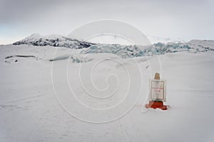 `Unguided trail` sign hanging on a safety cone on a path at Matanuska Glacier. photo